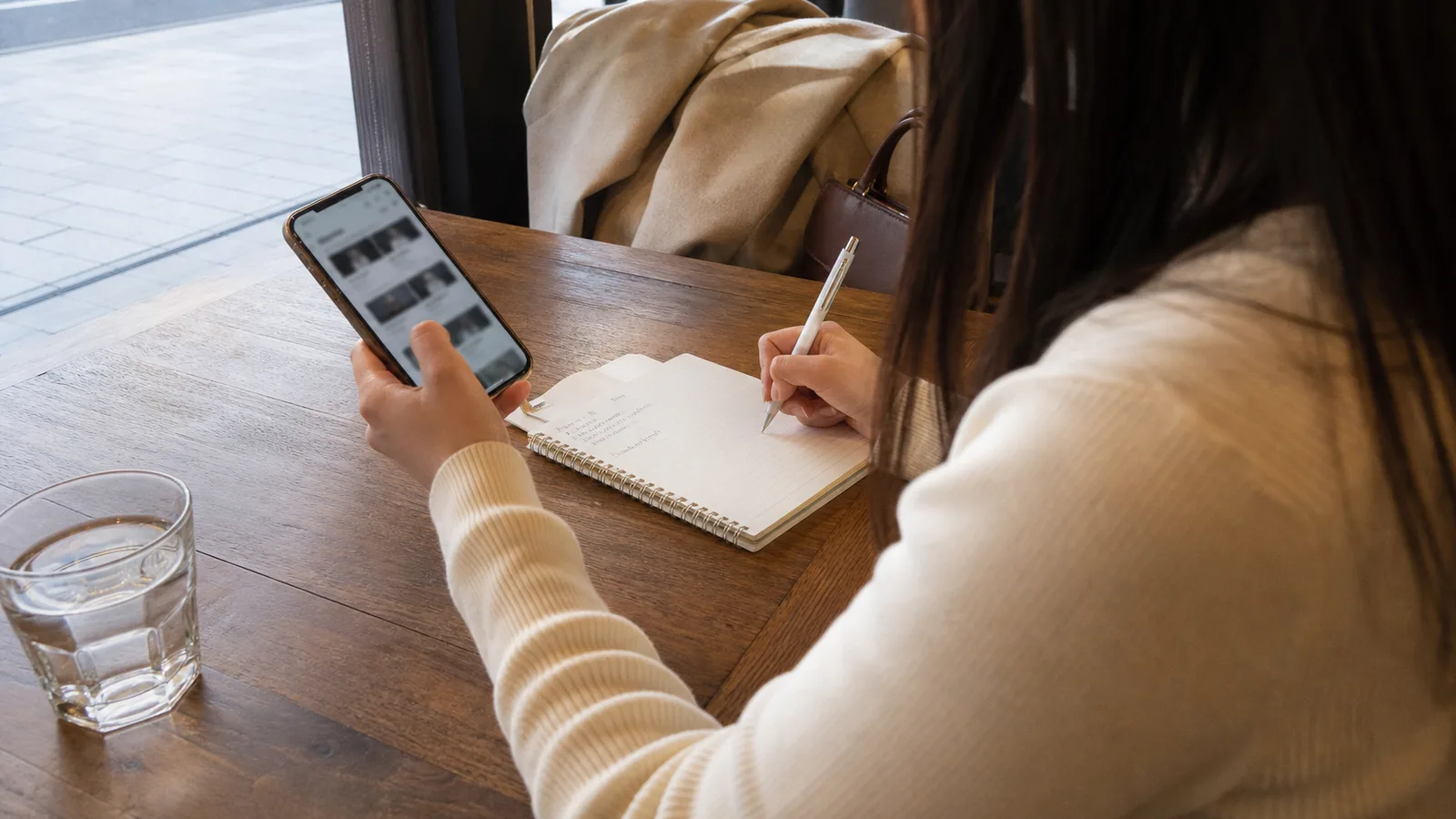 スマートフォンで求人を比較しながら確認事項をメモする様子
