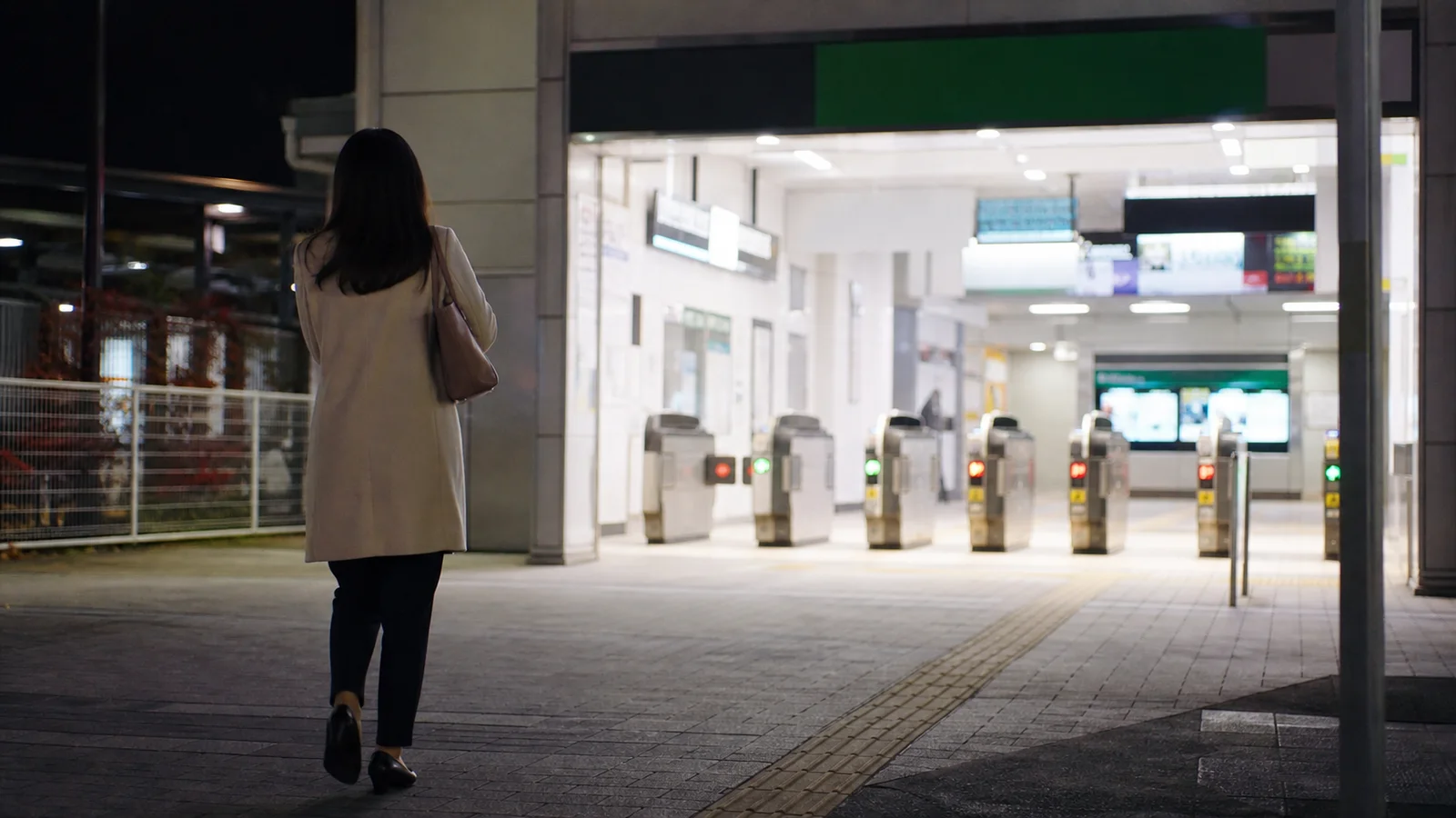 体験入店を終えて明るい駅へ向かう女性の後ろ姿